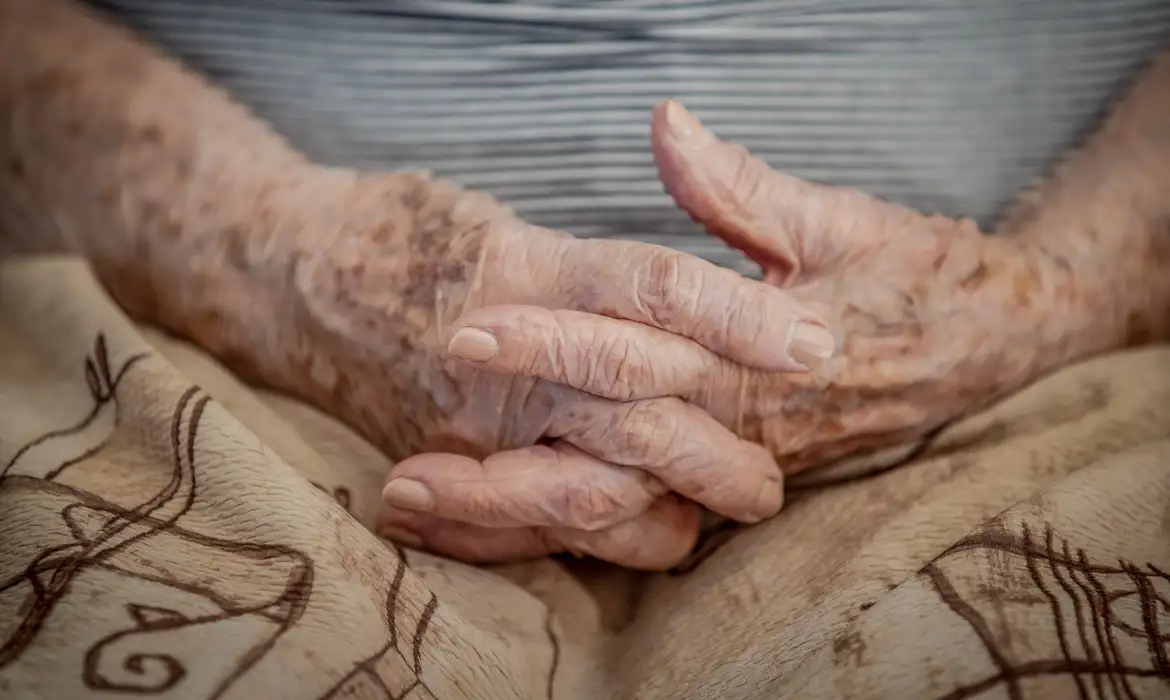 Imagem de um senhor de idade com Alzheimer comemorando o Fevereiro Roxo